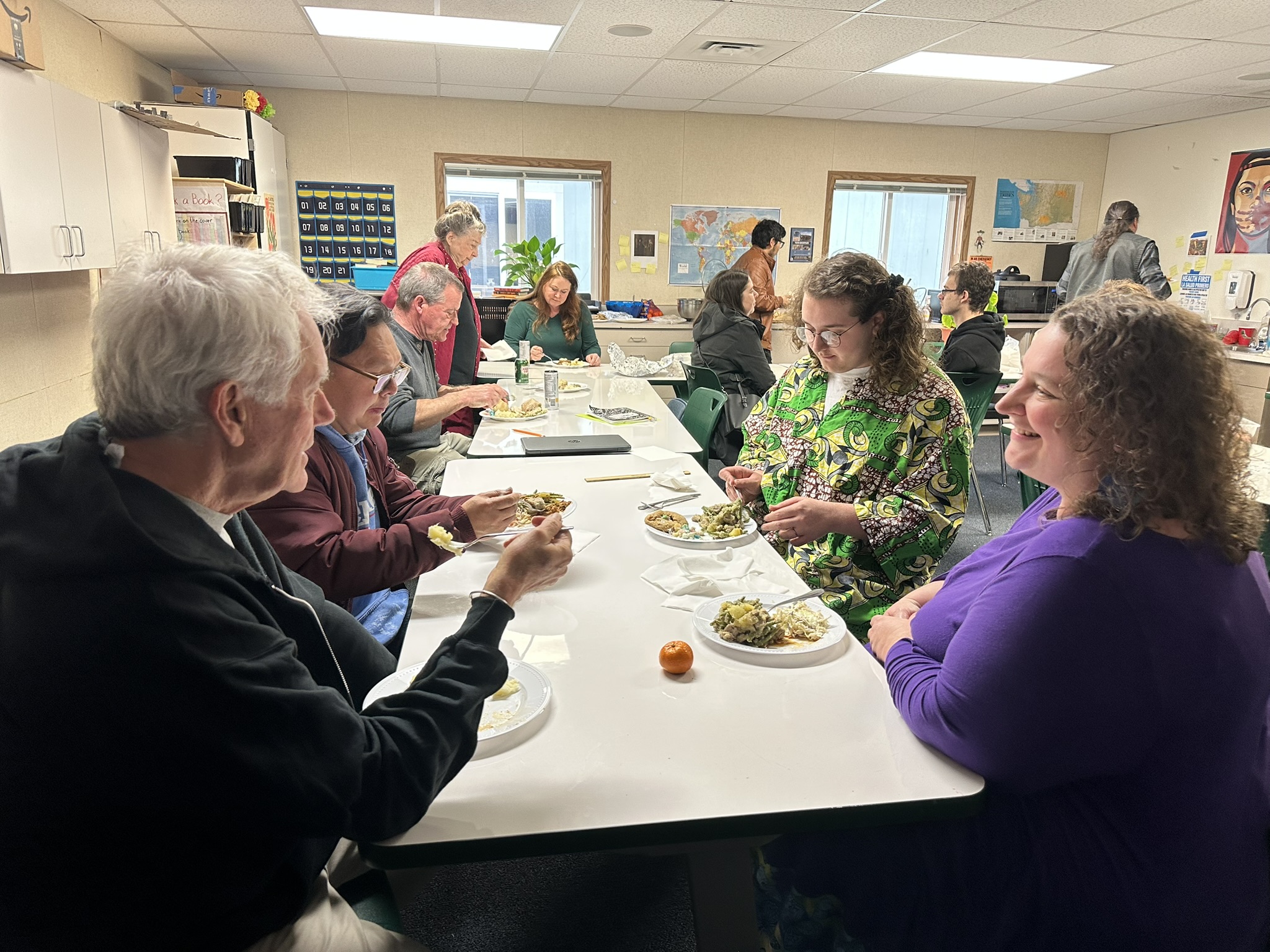 Students and community members sharing a meal together at school